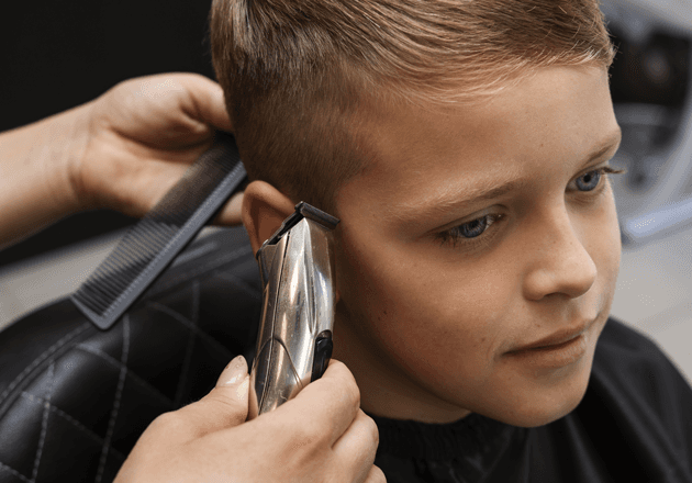 Blonder Junge beim Haarschnitt mit Maschine und Kamm: Kinderhaarschnitt bei John Barber Mailand